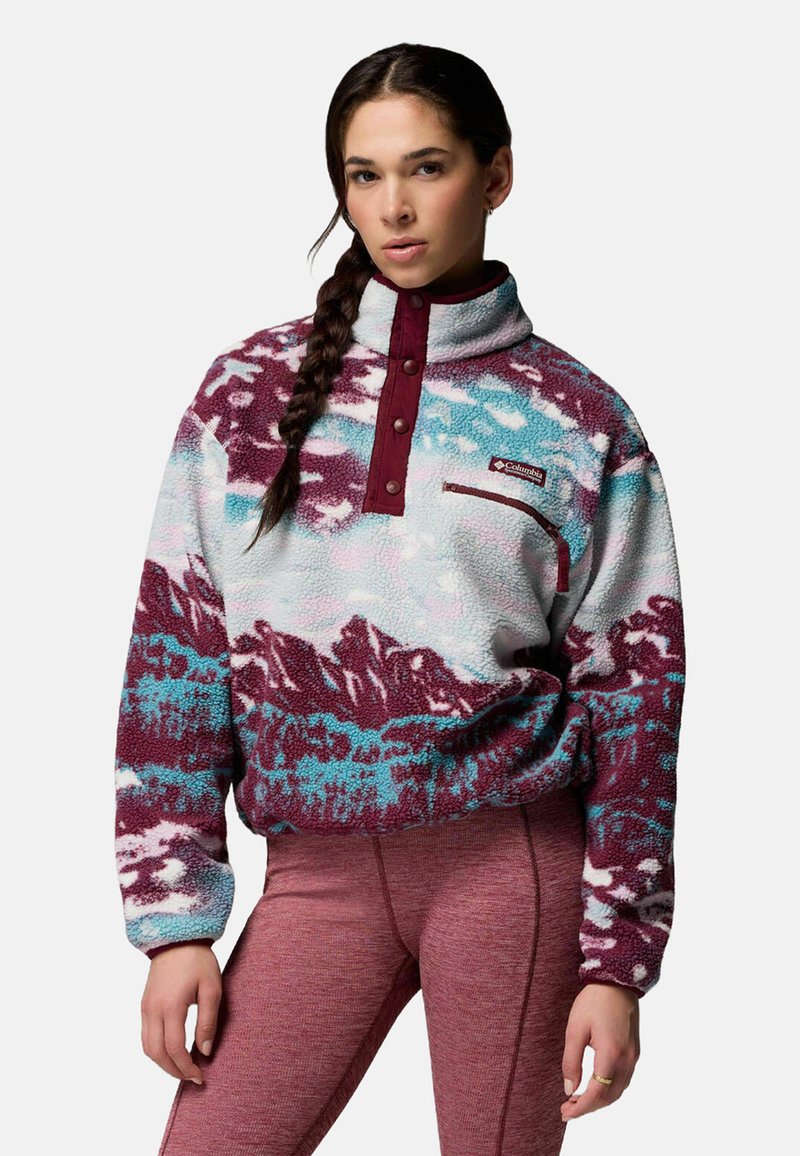 Sudadera de forro polar en azul, blanco y granate con patrones de montañas, cuello con media cremallera y bolsillo en el pecho. Tejido texturizado y acogedor con botones decorativos.