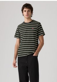 Černobílé pruhované tričko z bavlny s kulatým výstřihem a krátkými rukávy. Na hrudi má malý červený znak.