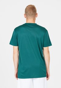 Kortärmad T-shirt i djupt teal, tillverkad av ett smidigt och lätt tyg. Enkel design med rund halsringning och inga synliga mönster eller accenter.