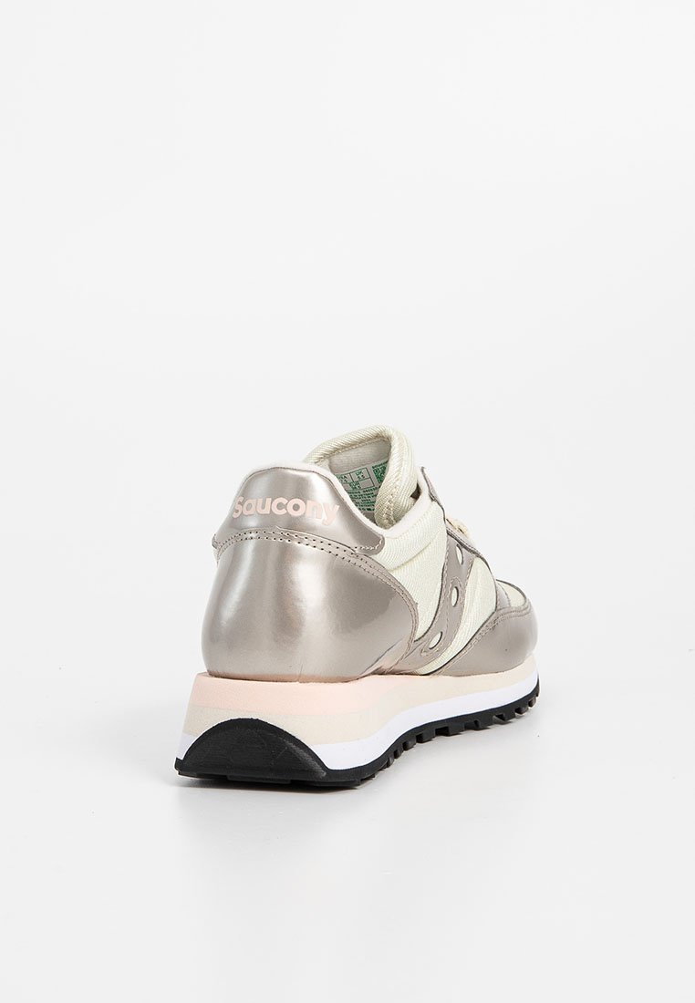 Zapatilla Saucony metálica y crema vista desde atrás, con suela negra, blanca y rosa claro sobre fondo blanco.