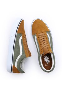 Brune og grønne semsket sneakers med hvite detaljer, gummisåle og tekstil, med flate lisser og logo på tungen.