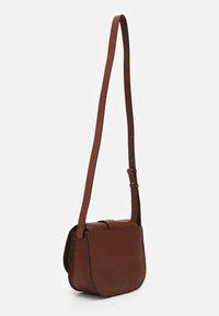 Brun læder crossbody taske med justerbar rem og klaplukning, vist mod en ensfarvet hvid baggrund.