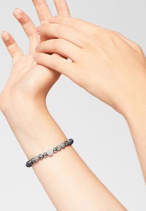 Perlenarmband mit grauen, blauen und silbernen Perlen sowie einem runden metallischen Akzent. Die elastische Gestaltung passt bequem um das Handgelenk.