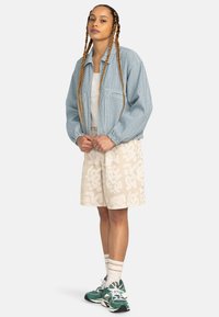 Blue and white striped jacket, white tank top, beige patterned shorts, green sneakers, and white socks with stripes. Casual outfit.
