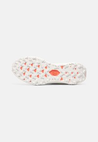 Suela de zapatilla blanca con patrón de tracción texturizado, con acentos naranjas en formas triangulares. Material de goma duradero.