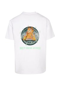 Hvid kortærmet T-shirt med en farverig grafik af en brændende pyramide og teksten "STOL IKKE PÅ NOGEN" i grøn.