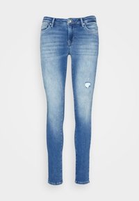 Jeans ajustados de denim azul claro, con áreas descoloridas y un desgarro desgastado en la rodilla derecha, con un diseño de bolsillo estándar.
