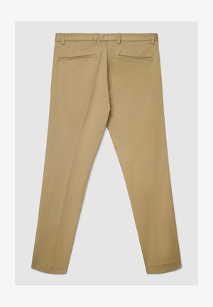 Pantalon beige en tissu doux, avec un devant plat, deux poches arrière et des jambes droites à la texture lisse.