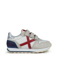 Zapatilla deportiva blanca con acentos rojos y grises, tres tiras de Velcro, materiales de ante y textil, y suela de goma texturizada.