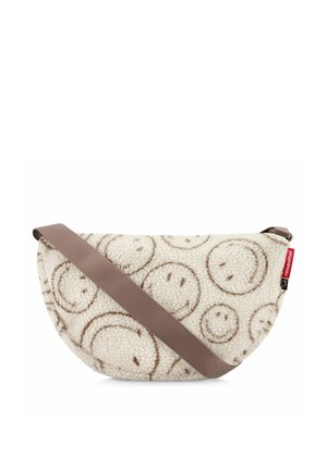 Bolso bandolera crema en forma de media luna con estampado de caras sonrientes marrones, correa gruesa marrón y pequeña etiqueta roja de la marca Reisenthel en el lateral.