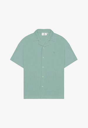 Chemise vert menthe à manches courtes, boutonnée, avec texture côtelée et petit logo brodé sur le côté gauche de la poitrine.
