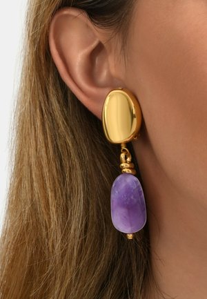 Boucles d'oreilles en or avec un clou en forme d'ovale et une pierre d'améthyste pendante, mettant en valeur une texture lisse et une riche teinte violette.