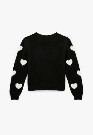 Schwarzer Pullover mit langen Ärmeln, der weiße Herzmuster an jedem Arm aufweist. Weicher Stoff, Rundhalsausschnitt, taillierte Passform.