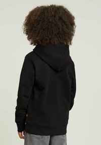 Sudadera con capucha negra de textura suave, que cuenta con un bolsillo tipo canguro, puños acanalados y un pequeño logo cerca del dobladillo.