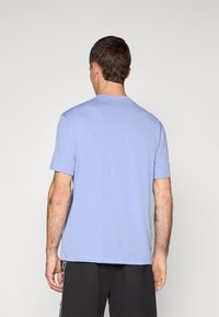 Ανοιχτό μπλε κοντομάνικο μπλουζάκι με στρογγυλή λαιμόκοψη, μαλακό ύφασμα βαμβακιού και άνετη εφαρμογή. Απλός σχεδιασμός, χωρίς έντονα μοτίβα ή διακοσμητικά στοιχεία.