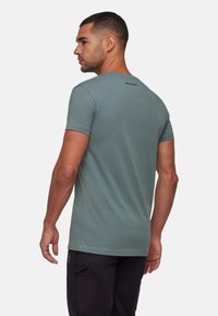 Zielony t-shirt z krótkim rękawem, wykonany z bawełny, z okrągłym dekoltem; posiada subtelne logo marki w czerni na górnej części pleców. Klasyczny krój.