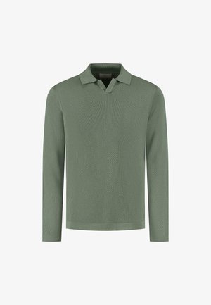Olīvzaļa garām piedurknēm polo krekls, kuram ir teksturēts adījuma dizains, iegriezts apkakle un taisna apakšmala ar minimālu detaļu skaitu.