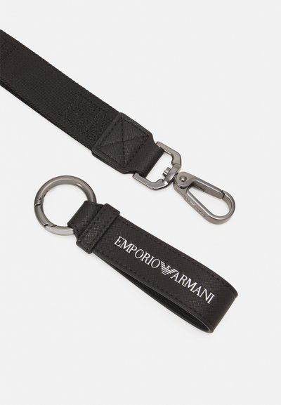 Laccio portachiavi in nylon nero presenta una clip resistente, un anello portachiavi circolare e il logo "Emporio Armani" in bianco. Superficie testurizzata, design elegante.