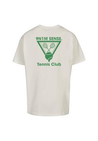 Balts kokvilnas T-krekls ar zaļu grafiku, kurā attēloti tenisa raketi un bumba, ar tekstu "9N1M SENSE. Tennis Club" trīsstūra dizainā aizmugurē.