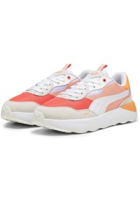 Zapatillas Puma con materiales de malla y gamuza, predominantemente blancas, con acentos en rosa y naranja, que cuentan con una suela acolchada y un diseño de cordones.