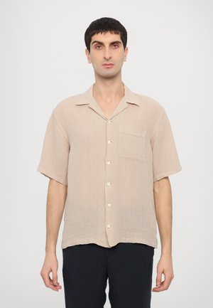 Short-sleeve, beige linen shirt with a pointed collar, chest pocket, and five button closure. Soft texture; casual, loose fit.