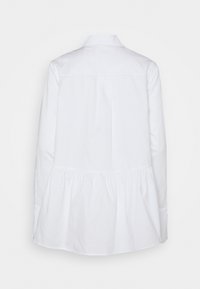 Blusa blanca de manga larga con dobladillo plisado, cuello y cierre de botón oculto; fabricada en tejido suave con un corte clásico.