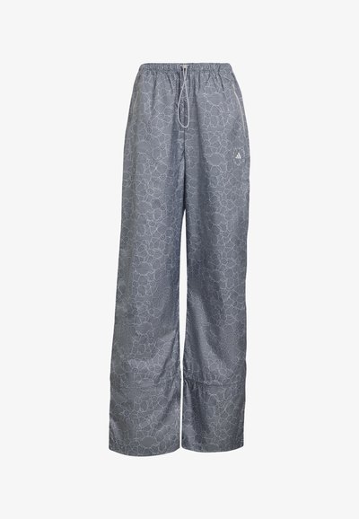 Gray wide-leg pants with white floral lace pattern, elastic waistband, drawstring, and small Adidas logo on right thigh.
