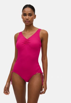 Bañador rosa de una sola pieza con escote en V, detalle de recogido en la parte delantera y lazos ajustables en los laterales. Textura suave y diseño ceñido.