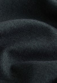 Tmavozelená tkanina s textúrovaným, tkaným vzhľadom. Materiál je mäkký a mierne chlpatý, s pevnou, zložitou väzbou.