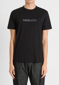 Zwart katoenen T-shirt met korte mouwen, voorzien van het "MORATO"-logo in reflecterend materiaal over de borst. Eenvoudige ronde halslijn, relaxed fit.