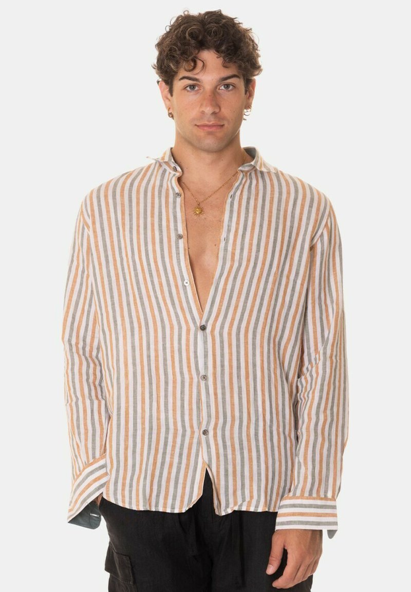 Camicia a maniche lunghe dal taglio morbido, bianca e con righe arancioni, dotata di un'apertura frontale, orlo curvo e texture morbida in lino.