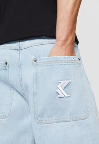 Karl Kani HEAVY DISTRESSED - Džinsa auduma šorti - bleached blue