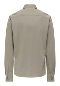 Hemd met lange mouwen in lichtbeige, met een omgeslagen kraag en geribbelde manchetten met knopen. Soepele textuur en eenvoudig ontwerp aan de achterkant zonder afbeeldingen.