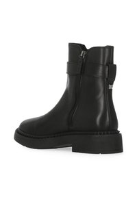 Stivaletti neri in pelle liscia, con cerniera laterale, suola robusta e cinturino decorativo vicino alla caviglia con dettaglio accentuato.