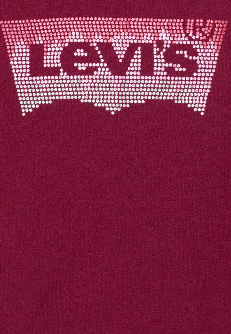 Bordeauxrotes T-Shirt mit einem Levi's-Logo aus glänzenden Nieten, vor einem helleren Verlaufshintergrund. Glattes Baumwollgewebe.