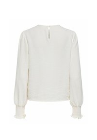Blouse blanche à manches longues en tissu texturé, poignets froncés et petite ouverture fermée par un bouton en forme de trou de serrure dans la nuque au dos.