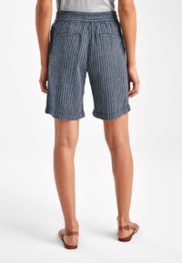 Niebieskie szorty w paski z podwiniętym dołem i elastycznym pasem. Posiadają dwie tylne kieszenie i luźny krój, wykonane z lekkiego materiału.