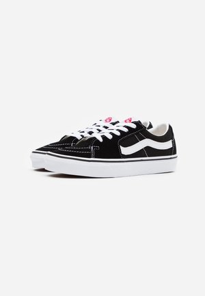 Black suede sneakers with white laces, featuring a prominent white side stripe and black rubber sole, showcasing contrast stitching details.