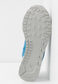 Chaussure de sport avec une semelle en caoutchouc gris texturé, une tige en maille bleue et des accents blancs. Motif de traction remarquable sur la semelle pour une bonne adhérence.