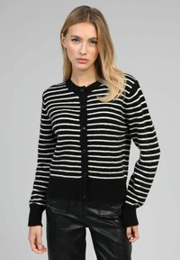 Cardigan rayé noir et blanc avec un col rond, des boutons à l'avant et des poignets et un ourlet côtelés. Fabriqué en matériau tricoté doux.