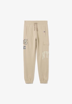Beige sweatpants gemaakt van zachte stof met taps toelopende enkels. Voorzien van zakken, bedrukte ontwerpen en een elastische tailleband met trekkoord.