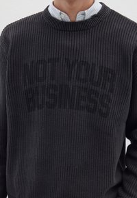 Dunkelgrauer Strickpullover mit geripptem Muster und Rundhalsausschnitt, ausgestattet mit einem dezenten, tonalen Schriftmuster auf der Vorderseite.