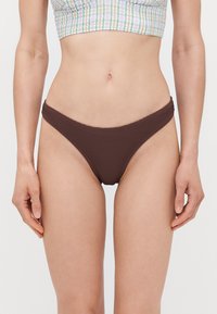 Rjavi bikini spodnji del z nizkim pasom. Gladka tekstura in ukrivljen pas. Minimalističen dizajn brez vzorcev ali dodatnih detajlov.