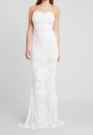 Witte strapless kanten jurk met ingewikkelde bloemen- en geometrische patronen, aansluitende pasvorm en een zoom tot op de grond.