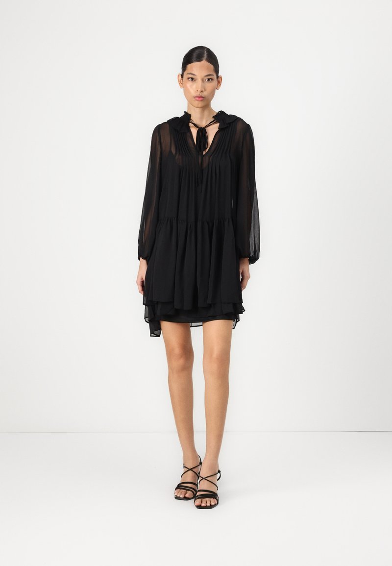 Μαύρο, Tiered φόρεμα με μακριά μανίκια, που διαθέτει πλισέ κορσέ και δέσιμο στον λαιμό. Διαφανές ύφασμα με στρωτό τελείωμα.