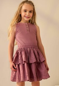 Fliederfarbenes ärmelloses Kleid mit einem gerippten Oberteil, drei Holzknöpfen und einem ausgestellten Rock mit gestickten Durchbruchsdetails.