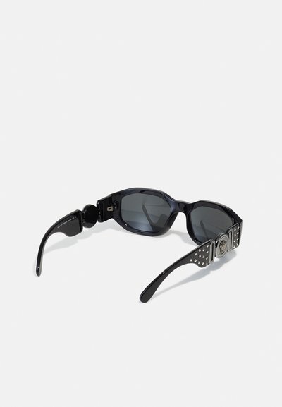 Black sunglasses with an angular frame, dark lenses, and decorative silver accents on the arms featuring studded details.