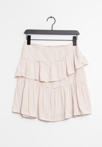 Světle růžová vícedílná sukně s řasenými vrstvami, vyrobená z měkké látky. Má elastický pas a visí na černém ramínku.