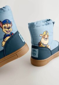 Blaue gefütterte Kinderschuhe mit Cartoon-Hunden, einem gepolsterten Obermaterial, strukturierten marineblauen Akzenten und einer Gummisohle.