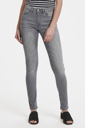 Gray skinny jeans made of denim, featuring a high waist, five-pocket design, and a subtle wash. Paired with black open-toe mules.